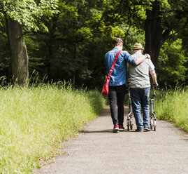 Rückenansicht von Großvater und Enkel beim Spaziergang in der Natur - UUF007590