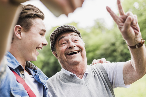 Großvater und Enkel machen Selfie mit Smartphone, lizenzfreies Stockfoto