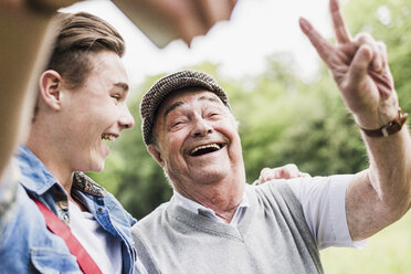 Grandfather and grandson taking selfie with smartphone - UUF007594