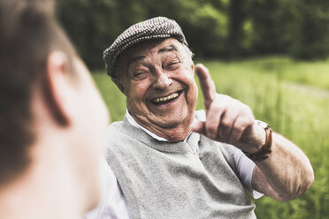 Porträt eines lachenden älteren Mannes im Gespräch mit seinem Enkel - UUF007598