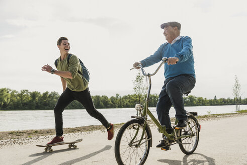 Grandfather and grandson having fun together at riverside - UUF007630