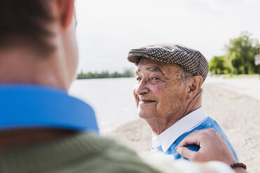 Porträt eines lächelnden älteren Mannes mit Blick auf seinen Enkel - UUF007634