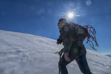 Italy, Umbria, Sibillini National Park, Hiker against the sun in winter - LOMF000275