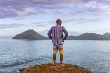 Indonesia, Sumbawa island, Young man standing on viewpoint - KNTF000299