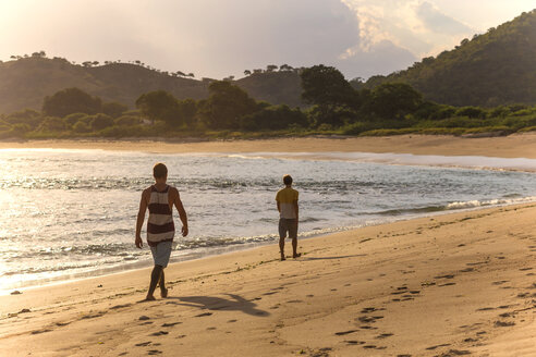 Indonesien, Insel Sumbawa, Zwei junge Männer am Strand - KNTF000305