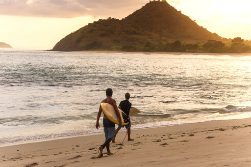 Indonesien, Insel Sumbawa, Surfer am Strand am Abend - KNTF000307