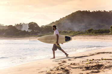 Indonesien, Insel Sumbawa, Surfer am Strand am Abend - KNTF000311