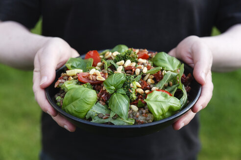 Hände halten Schüssel mit zubereitetem Reissalat - EVGF002969