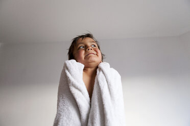 Porträt eines kleinen Jungen mit Duschtuch, der nach dem Baden lustige Gesichter zieht - VABF000513
