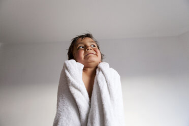 Portrait of little boy with shower towel pulling funny faces after taking a bath - VABF000513