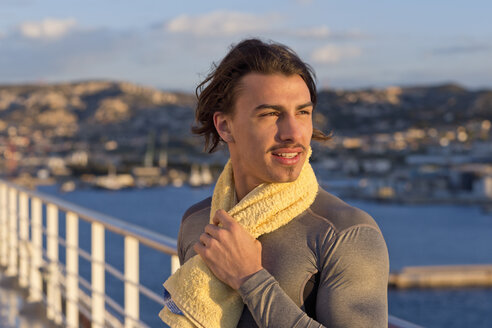Porträt eines jungen Mannes mit Handtuch auf dem Deck eines Kreuzfahrtschiffs - ONBF000047