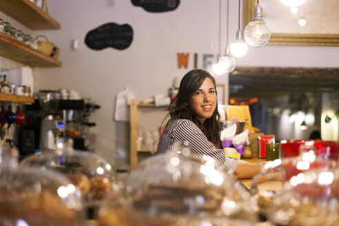 Junge Frau arbeitet in ihrem eigenen kleinen Cafe - VABF000523