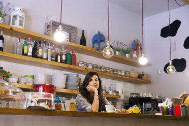 Junge Frau arbeitet in ihrem eigenen kleinen Cafe - VABF000525