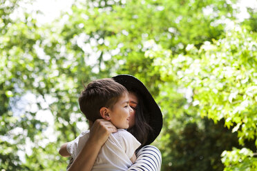 Mother and son hugging outdoors - VABF000533