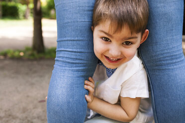 Porträt eines glücklichen Jungen zwischen den Beinen der Mutter - VABF000534