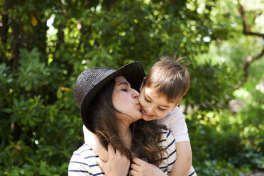 Mother kissing son outdoors - VABF000541