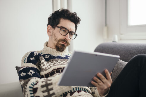 Portrait of pensive man using digital tablet - LCUF000024