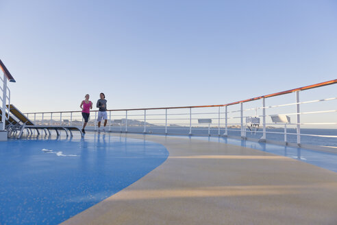 Junges Paar joggt auf dem Schiffsdeck eines Kreuzfahrtschiffs, Mittelmeer - ONBF000058