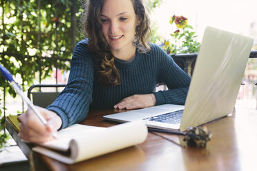 Young woman sitting on balcony using laptop - BOYF000372