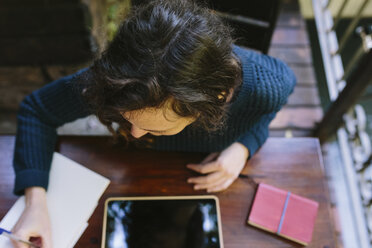 Young woman sitting on balcony, working with digital tablet - BOYF000390