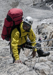 Nepal, Himalaya, Solo Khumbu, Everest region Ama Dablam, mountaineer climbing up rocks - ALRF000509