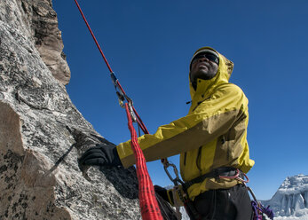 Nepal, Himalaya, Solo Khumbu, Everest region Ama Dablam, mountaineer with rope at rock face looking up - ALRF000510