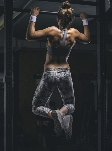 Female athlete exercising chin-ups stock photo