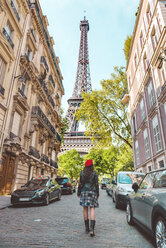Frankreich, Paris, Eiffelturm zwischen den Gebäuden, Straße in der Nähe und Frau mit roter Baskenmütze auf der Straße - GEMF000914