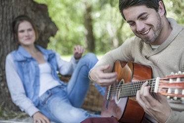 Junges Paar beim Picknick mit Gitarre spielendem Mann - ZEF008676