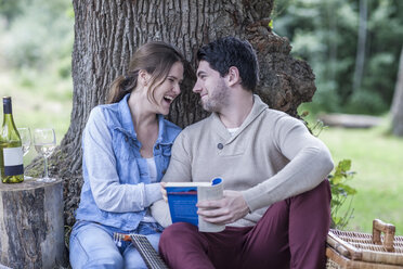 Glückliches junges Paar bei einem Picknick mit Weißwein - ZEF008679