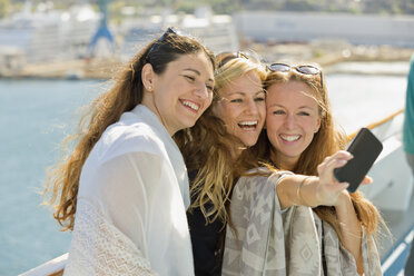 Drei glückliche Frauen machen ein Selfie auf einem Kreuzfahrtschiff - ONBF000067