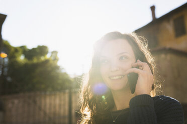 Porträt einer lächelnden Frau, die mit einem Smartphone telefoniert - BOYF000403