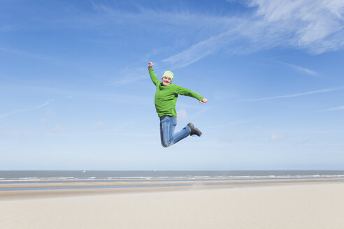 Enthusiastischer reifer Mann springt am Strand - GWF004742