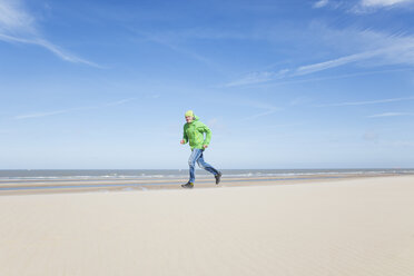 Mature man running on beach - GWF004743