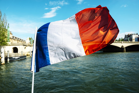 Frankreich, Paris, wehende französische Flagge mit Ile de la Cite im Hintergrund, lizenzfreies Stockfoto