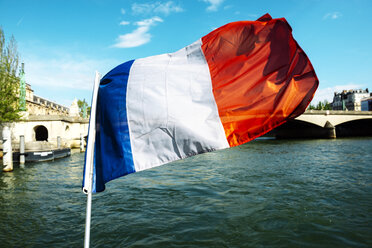 Frankreich, Paris, wehende französische Flagge mit Ile de la Cite im Hintergrund - GEMF000916