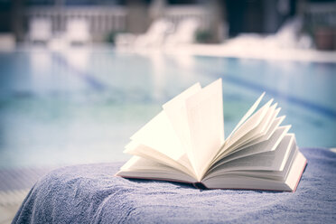 Aufgeschlagenes Buch auf dem Handtuch im Schwimmbad - CMF000468