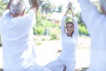 Älteres Paar, das zusammen mit einem Lehrer Yoga praktiziert - ZEF008691