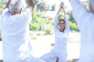 Elderly couple practicing yoga together with instructor - ZEF008691