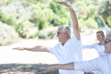 Ein älterer Mann streckt seine Arme während einer Yogastunde - ZEF008693
