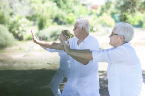 Älteres Paar, das zusammen mit einem Lehrer Yoga praktiziert - ZEF008694