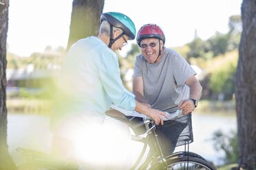 Smiling elderly couple on bicycles - ZEF008700