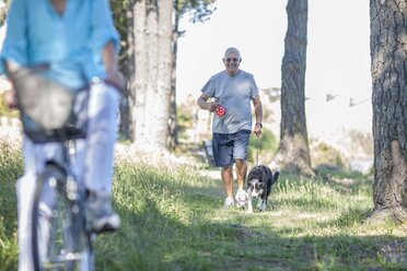 Älterer Mann geht mit seinem Hund im Wald spazieren - ZEF008702