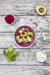 Schüssel mit Avocado-Himbeer-Salat mit Feta und Schalen mit Zutaten - LVF004943