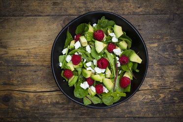 Schale mit Avocado-Himbeer-Salat mit Feta auf dunklem Holz - LVF004944