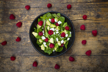 Schale mit Avocado-Himbeer-Salat mit Feta auf dunklem Holz - LVF004945