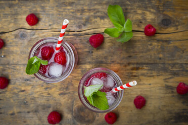 Himbeersekt in Gläsern, Trinkhalm, Minze und Himbeeren - LVF004948