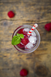 Raspberry champagne in glass, drinking straw, mint and raspberries - LVF004949