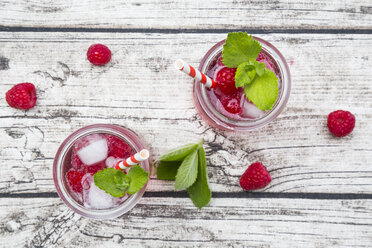 Raspberry champagne in glasses, drinking straw, mint and raspberries - LVF004950