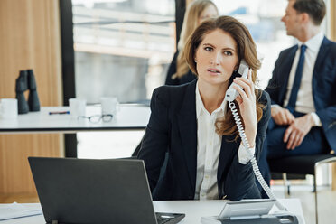 Businesswoman at office desk on the phone - CHAF001786